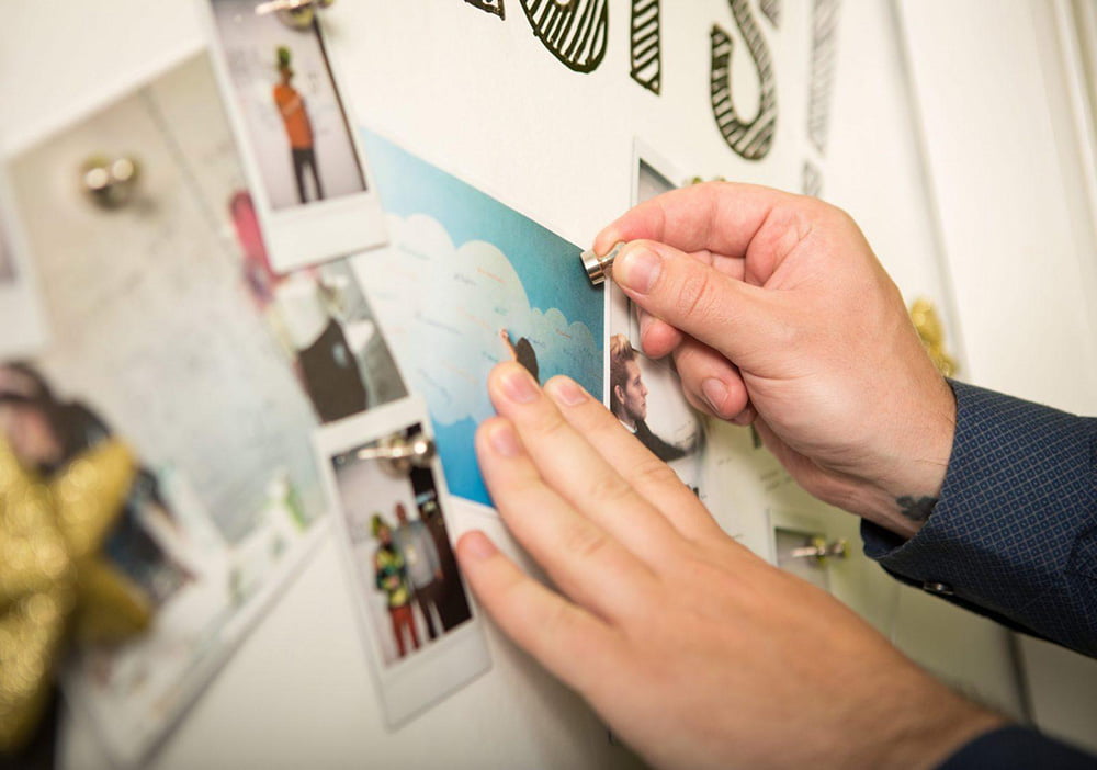person hanging a sheet onto a smart magnetic whiteboard surface